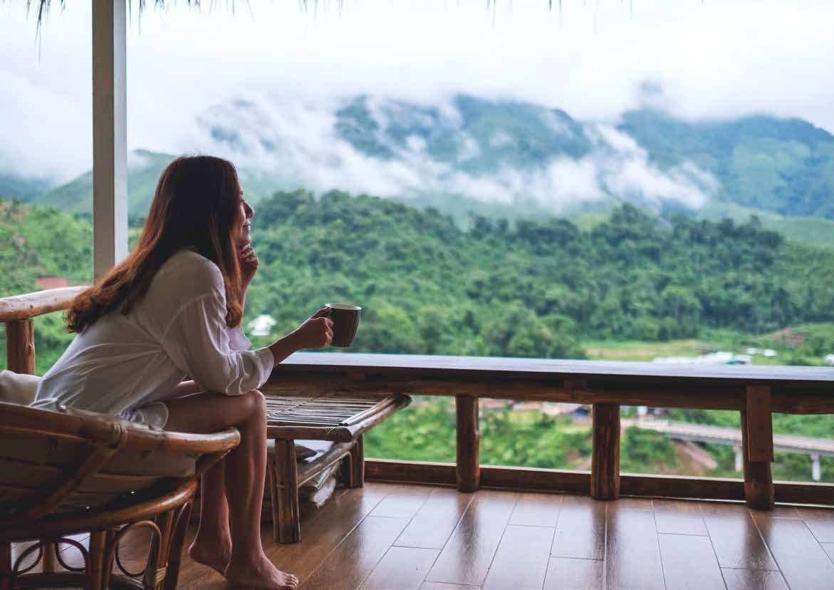 Morning coffee on a balcony overlooking misty green hills